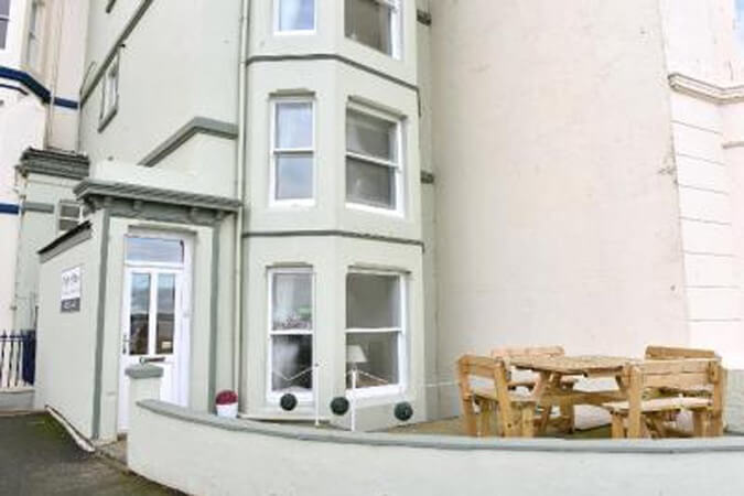 The hotel's side terrace with a wooden picnic table