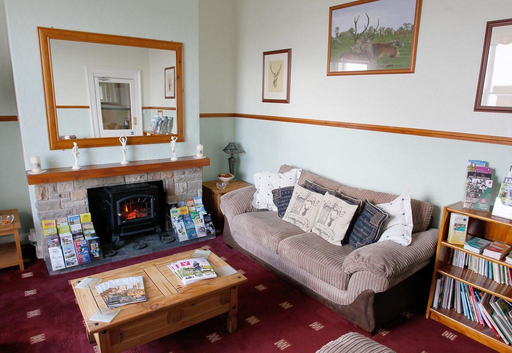 The guest lounge with a stone fireplace, sofa and bookshelves